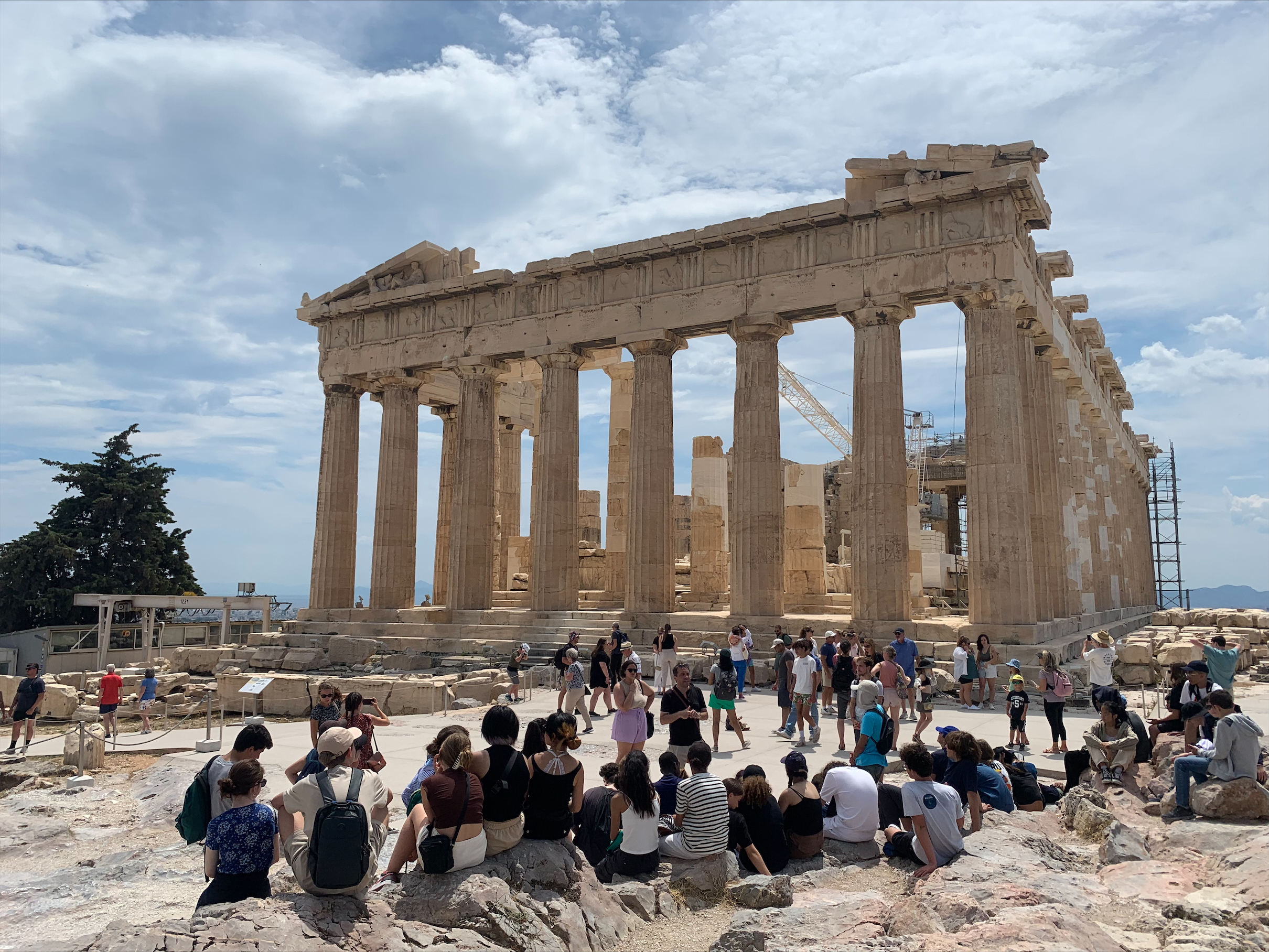 Un groupe scolaire accompagné de leur guide devant le Parthénon, lors d'un voyage éducatif organisé par THALYSSEA, explorant l'histoire et la culture de la Grèce antique.